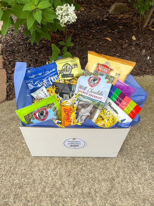 Deluxe Welcome Box packed with Michigan snacks in blue tissue paper