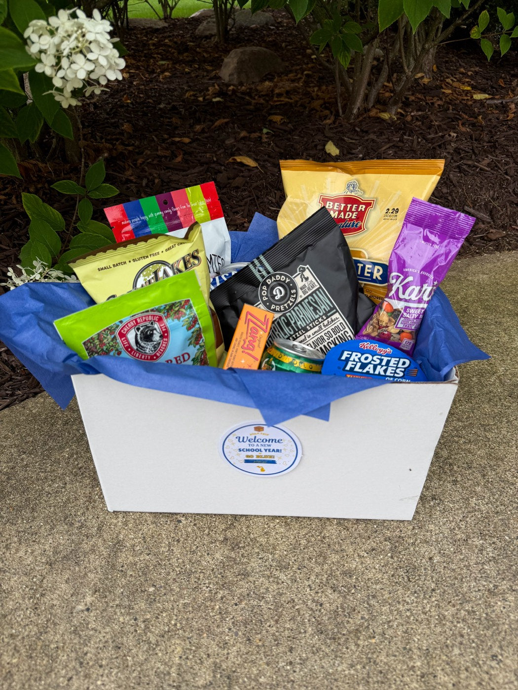 Signature Welcome Box packed with Michigan snacks in blue tissue paper